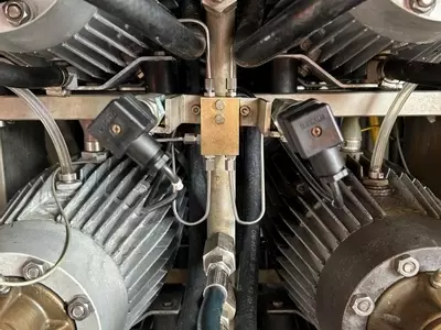 Replacement capillary pipes installed on the pressure manifold of a Nilfisk Delta Booster multi-pump pressure washer after repair.